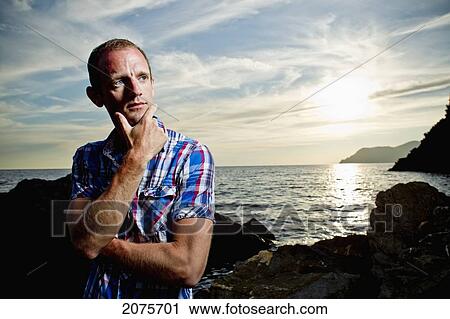 A Young Man Stands On The Shore During A Sunset Over The Mediterranean; Manarola Italy View Large Photo Image Stock Image - A Young Man Stands On The Shore During A Sunset Over The Mediterranean; Manarola Italy. Fotosearch