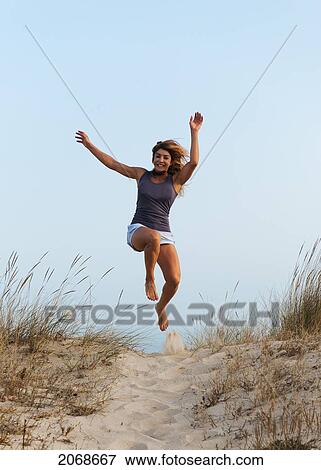 A Young Woman Running And Leaping Down A Sandy Path; Tarifa Cadiz Andalusia Spain View Large Photo Image Stock Photo - A Young Woman Running And Leaping Down A Sandy Path; Tarifa Cadiz Andalusia Spain. Fotosearch