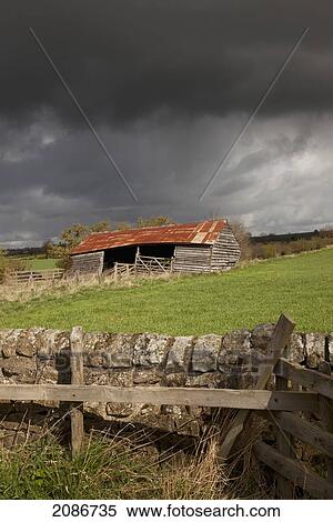 Stock Photography - An old wooden barn under storm clouds; yorkshire england. Fotosearch
