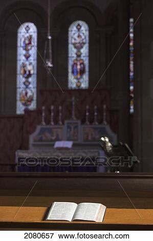 An open bible on a wooden ledge with stained glass windows and the altar of a church; howick northumberland england View Large Photo Image Stock Photo - An open bible on a wooden ledge with stained glass windows and the altar of a church; howick northumberland england. Fotosearch