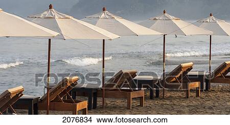 Beach chairs and white umbrellas lined up on the beach along the ocean; sayulita mexico View Large Photo Image Picture - Beach chairs and white umbrellas lined up on the beach along the ocean; sayulita mexico. Fotosearch