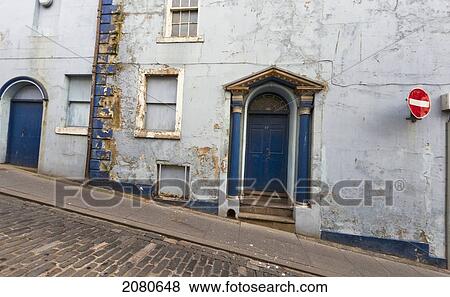 Blue doorways on a building and a street going uphill with a no entry sign mounted on the wall; berwick northumberland england View Large Photo Image Stock Photo - Blue doorways on a building and a street going uphill with a no entry sign mounted on the wall; berwick northumberland england. Fotosearch