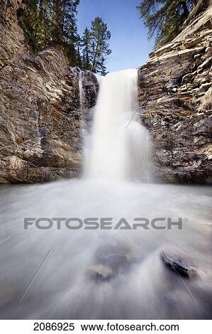 Stock Photography - Blur of water flowing down a waterfall; nordegg alberta canada. Fotosearch