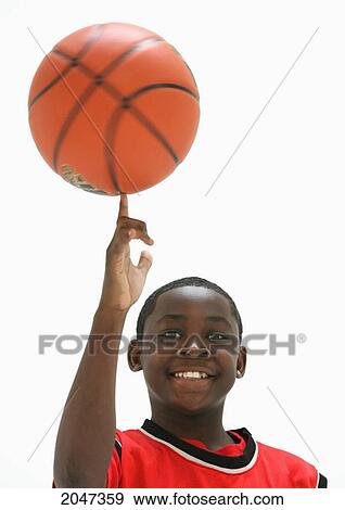Stock Photo - Boy In Red Jersey Spinning Basketball On His Finger; Portland Oregon United States Of America. Fotosearch