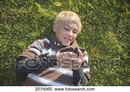 Boy With Blond Hair Laying On The Grass With Smart Phone; Moraga California United States Of America View Large Photo Image Stock Image - Boy With Blond Hair Laying On The Grass With Smart Phone; Moraga California United States Of America. Fotosearch