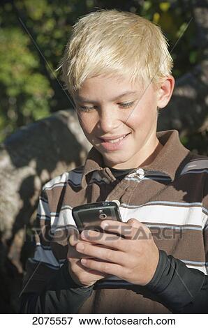 Stock Photo - Boy With Blond Hair Plays With Smart Phone Outside; Moraga California United States Of America. Fotosearch