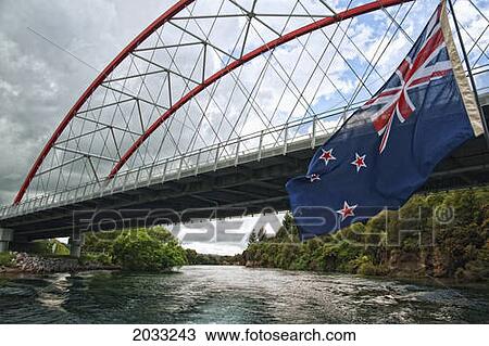 Stock Image - Bridge Over Waikato River With The New Zealand Flag; Taupo New Zealand. Fotosearch