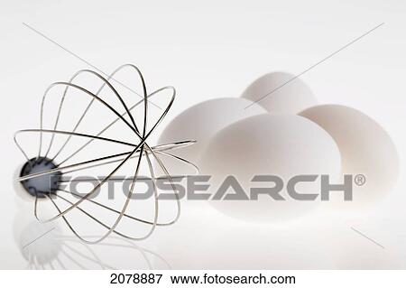Chef's whisk with a group of eggs on a white reflective background; calgary alberta canada View Large Photo Image Stock Photo - Chef's whisk with a group of eggs on a white reflective background; calgary alberta canada. Fotosearch