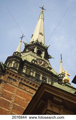 Clock tower and crosses at the top of a building in old town; stockholm sweden View Large Photo Image Picture - Clock tower and crosses at the top of a building in old town; stockholm sweden. Fotosearch