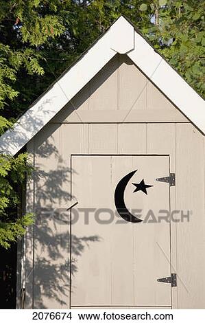 Close up of wooden outhouse with crescent moon and star cut out on door; flesherton ontario canada View Large Photo Image Picture - Close up of wooden outhouse with crescent moon and star cut out on door; flesherton ontario canada. Fotosearch