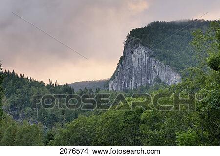Clouds at sunset and a cliff with trees; norway View Large Photo Image Picture - Clouds at sunset and a cliff with trees; norway. Fotosearch