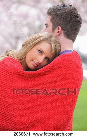 Couple Cuddled Up In A Red Blanket With Young Woman Looking At The Camera; Portland Oregon United States Of America View Large Photo Image Stock Image - Couple Cuddled Up In A Red Blanket With Young Woman Looking At The Camera; Portland Oregon United States Of America. Fotosearch