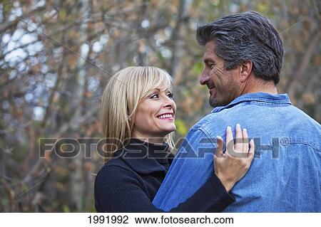 Couple Embracing And Spending Quality Time Together In A Park In Autumn; St. Albert Alberta Canada View Large Photo Image Stock Image - Couple Embracing And Spending Quality Time Together In A Park In Autumn; St. Albert Alberta Canada. Fotosearch