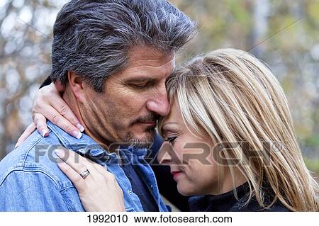 Couple Embracing And Spending Quality Time Together In A Park In Autumn; St. Albert Alberta Canada View Large Photo Image Stock Image - Couple Embracing And Spending Quality Time Together In A Park In Autumn; St. Albert Alberta Canada. Fotosearch