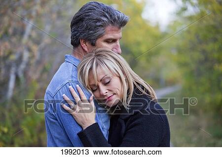 Couple Embracing And Spending Quality Time Together In A Park In Autumn; St. Albert Alberta Canada View Large Photo Image Stock Image - Couple Embracing And Spending Quality Time Together In A Park In Autumn; St. Albert Alberta Canada. Fotosearch