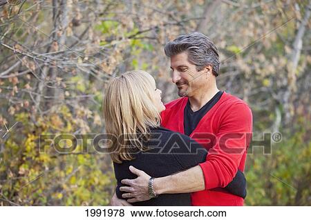 Couple Embracing And Spending Quality Time Together In A Park In Autumn; St. Albert Alberta Canada View Large Photo Image Stock Photo - Couple Embracing And Spending Quality Time Together In A Park In Autumn; St. Albert Alberta Canada. Fotosearch