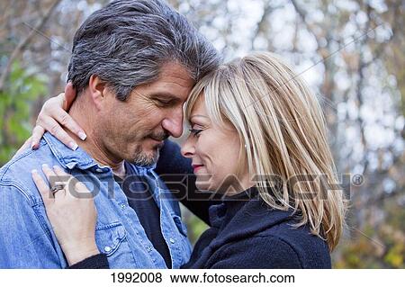Couple Embracing And Spending Quality Time Together In A Park In Autumn; St. Albert Alberta Canada View Large Photo Image Stock Photo - Couple Embracing And Spending Quality Time Together In A Park In Autumn; St. Albert Alberta Canada. Fotosearch