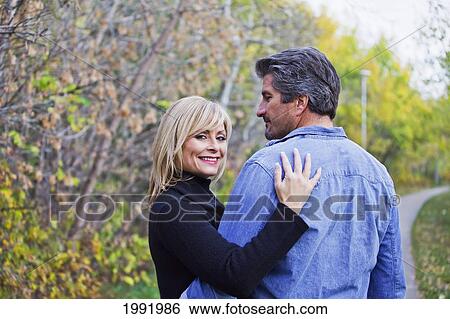 Couple Embracing And Spending Quality Time Together In A Park In Autumn; St. Albert Alberta Canada View Large Photo Image Stock Photograph - Couple Embracing And Spending Quality Time Together In A Park In Autumn; St. Albert Alberta Canada. Fotosearch