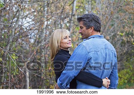 Couple Embracing And Spending Quality Time Together In A Park In Autumn; St. Albert Alberta Canada View Large Photo Image Stock Photograph - Couple Embracing And Spending Quality Time Together In A Park In Autumn; St. Albert Alberta Canada. Fotosearch