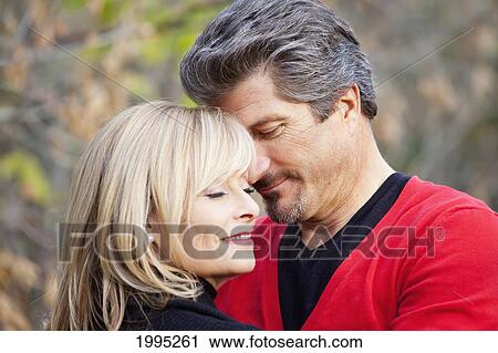 Stock Image - Couple Embracing In A Park In Autumn; St. Albert Alberta Canada. Fotosearch