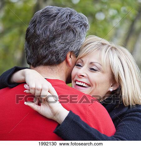Couple Hugging In A Park In Autumn; St. Albert Alberta Canada View Large Photo Image Stock Image - Couple Hugging In A Park In Autumn; St. Albert Alberta Canada. Fotosearch