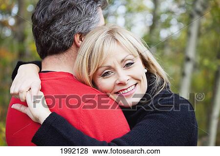 Couple Hugging In A Park In Autumn; St. Albert Alberta Canada View Large Photo Image Stock Photo - Couple Hugging In A Park In Autumn; St. Albert Alberta Canada. Fotosearch