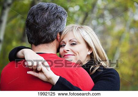 Stock Photography - Couple Hugging In A Park In Autumn; St. Albert Alberta Canada. Fotosearch