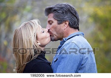 Couple Kissing In A Park In Autumn; St. Albert Alberta Canada View Large Photo Image Stock Photography - Couple Kissing In A Park In Autumn; St. Albert Alberta Canada. Fotosearch