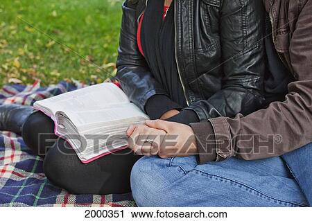 Couple Reading Bible And Praying Together In The Park; Edmonton Alberta Canada View Large Photo Image Stock Image - Couple Reading Bible And Praying Together In The Park; Edmonton Alberta Canada. Fotosearch