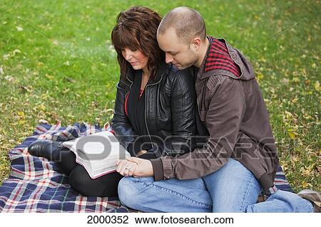 Couple Reading Bible And Praying Together In The Park; Edmonton Alberta Canada View Large Photo Image Stock Image - Couple Reading Bible And Praying Together In The Park; Edmonton Alberta Canada. Fotosearch