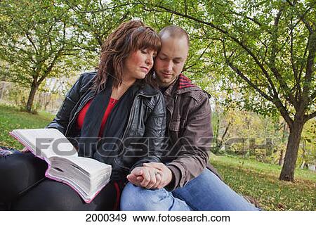 Couple Reading Bible And Praying Together In The Park; Edmonton Alberta Canada View Large Photo Image Stock Photo - Couple Reading Bible And Praying Together In The Park; Edmonton Alberta Canada. Fotosearch
