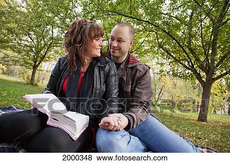 Stock Photo - Couple Reading Bible Together In The Park; Edmonton Alberta Canada. Fotosearch