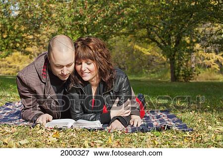 Couple Reading The Bible Together In A Park; Edmonton Alberta Canada View Large Photo Image Stock Photo - Couple Reading The Bible Together In A Park; Edmonton Alberta Canada. Fotosearch
