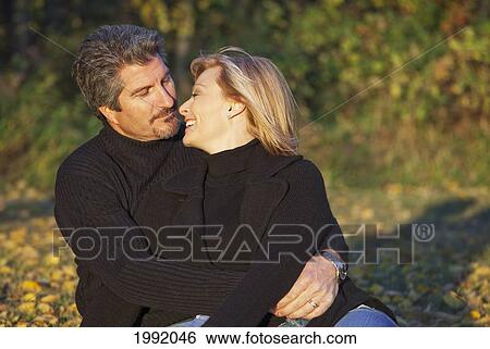 Couple Spending Quality Time Together In A Park In Autumn; St. Albert Alberta Canada View Large Photo Image Stock Photograph - Couple Spending Quality Time Together In A Park In Autumn; St. Albert Alberta Canada. Fotosearch