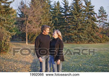 Couple Spending Quality Time Together In A Park In Autumn; St. Albert Alberta Canada View Large Photo Image Stock Photograph - Couple Spending Quality Time Together In A Park In Autumn; St. Albert Alberta Canada. Fotosearch