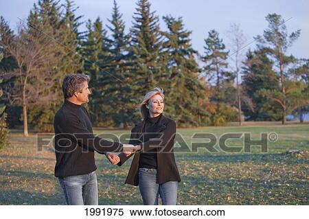Couple Swinging Each Other Around In A Park; St. Albert Alberta Canada View Large Photo Image Stock Photography - Couple Swinging Each Other Around In A Park; St. Albert Alberta Canada. Fotosearch