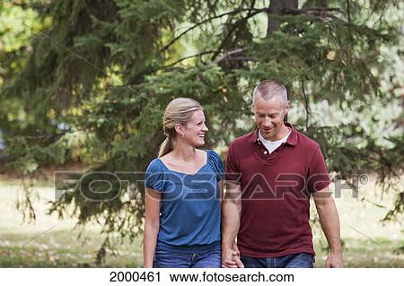 Couple Walking Together In A Park In Autumn; Edmonton Alberta Canada View Large Photo Image Stock Image - Couple Walking Together In A Park In Autumn; Edmonton Alberta Canada. Fotosearch