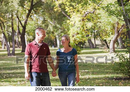 Couple Walking Together In A Park In Autumn; Edmonton Alberta Canada View Large Photo Image Stock Image - Couple Walking Together In A Park In Autumn; Edmonton Alberta Canada. Fotosearch