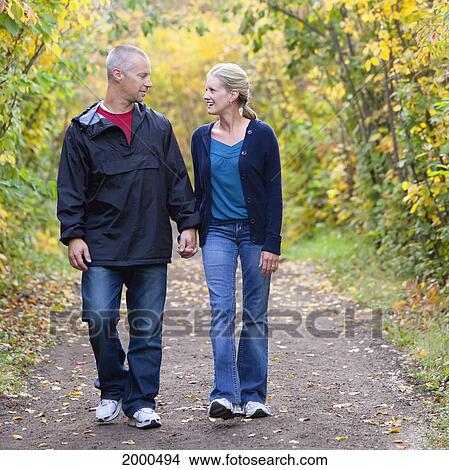 Couple Walking Together On A Park Path In Autumn; Edmonton Alberta Canada View Large Photo Image Picture - Couple Walking Together On A Park Path In Autumn; Edmonton Alberta Canada. Fotosearch