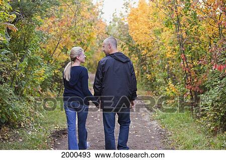 Couple Walking Together On A Park Path In Autumn; Edmonton Alberta Canada View Large Photo Image Stock Image - Couple Walking Together On A Park Path In Autumn; Edmonton Alberta Canada. Fotosearch