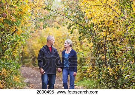 Couple Walking Together On A Park Path In Autumn; Edmonton Alberta Canada View Large Photo Image Stock Photography - Couple Walking Together On A Park Path In Autumn; Edmonton Alberta Canada. Fotosearch