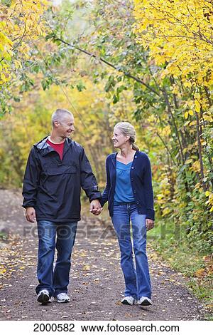 Couple Walking Together On A Path In A Park In Autumn; Edmonton Alberta Canada View Large Photo Image Stock Image - Couple Walking Together On A Path In A Park In Autumn; Edmonton Alberta Canada. Fotosearch