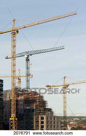 Cranes against a blue sky in a developing area; oslo norway View Large Photo Image Stock Image - Cranes against a blue sky in a developing area; oslo norway. Fotosearch