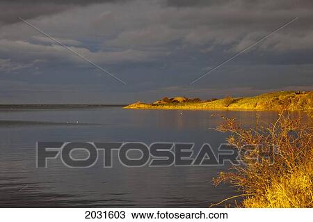 Dark Clouds Over The Water At Budle Bay With A Golden Shoreline; Northumberland England View Large Photo Image Stock Image - Dark Clouds Over The Water At Budle Bay With A Golden Shoreline; Northumberland England. Fotosearch