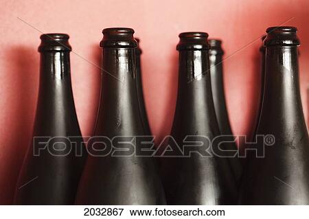 Stock Photo - Dark Glass Bottles On A Shelf Against A Pink Wall; Coolangatta Queensland Australia. Fotosearch