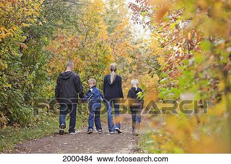 Picture - Family Walking Together On A Path In A Park In Autumn; Edmonton Alberta Canada. Fotosearch