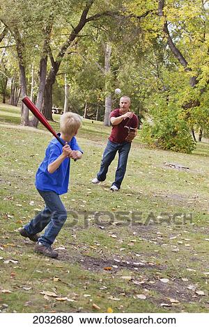 Stock Image - Father And Son Playing Baseball In A Park; Edmonton Alberta Canada. Fotosearch