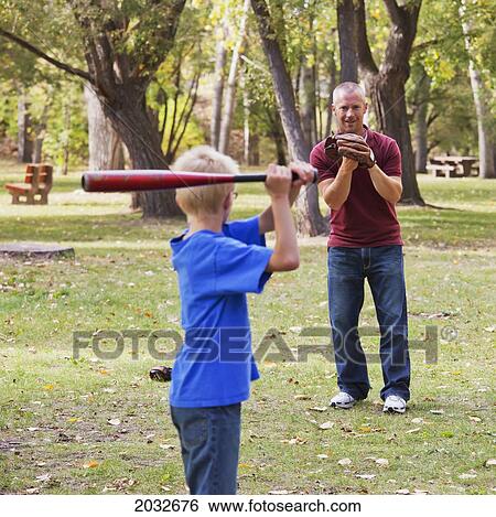 Stock Photograph - Father And Son Playing Baseball In A Park; Edmonton Alberta Canada. Fotosearch