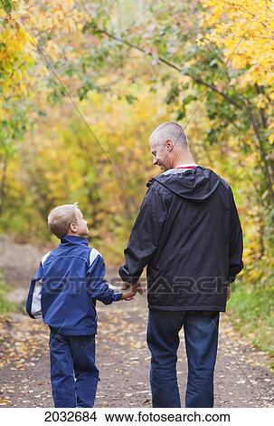 Picture - Father And Son Walking On A Path In A Park In Autumn; Edmonton Alberta Canada. Fotosearch