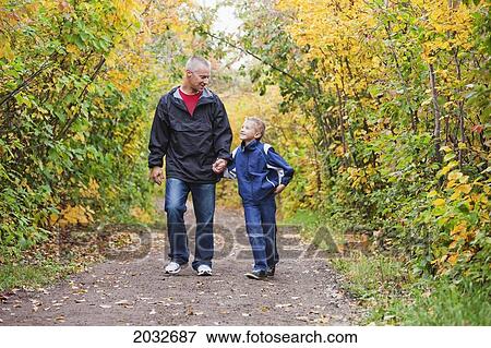 Father And Son Walking On A Path In A Park In Autumn; Edmonton Alberta Canada View Large Photo Image Stock Photo - Father And Son Walking On A Path In A Park In Autumn; Edmonton Alberta Canada. Fotosearch